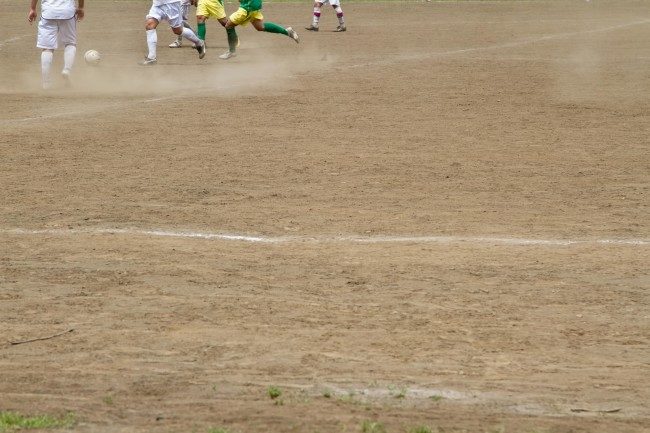 グラウンドでサッカーをする選手たち