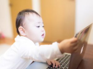 ノートパソコンを触る赤ちゃん