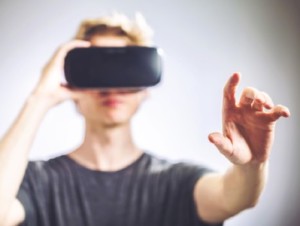 VRヘッドセットを付けて手を伸ばす人